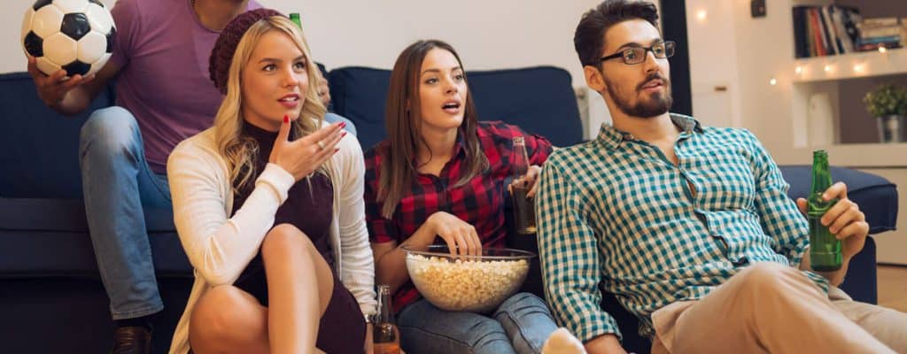 Group of friends watching wall mounted TV