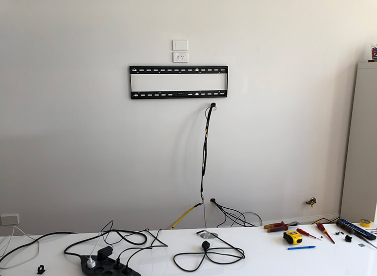 TV wall-mount bracket on external wall with cables hidden in wall