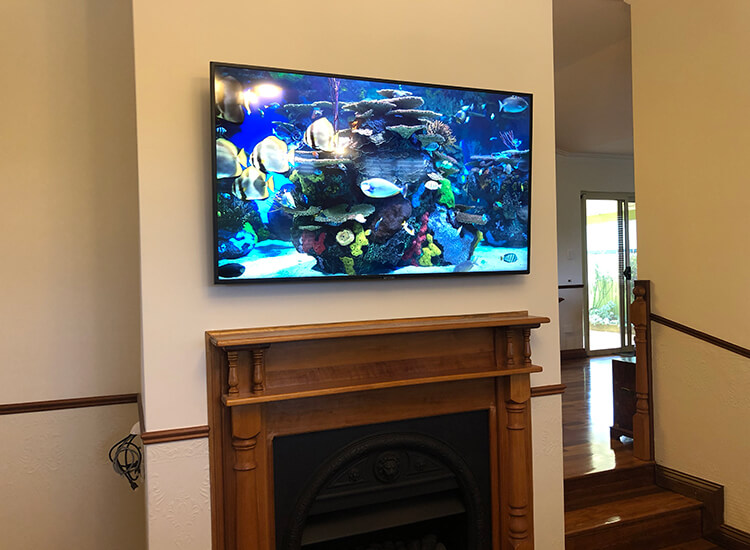 TV wall mounted above fireplace