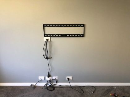 TV bracket is fitted and cables are punched through to an out of sight area on the other side of the wall.