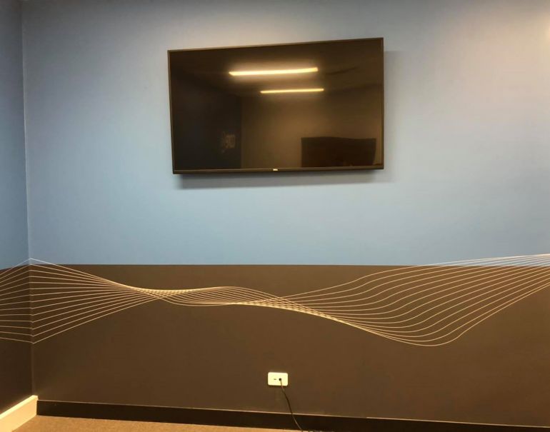 Wall mounted monitor screen in a Subiaco office.