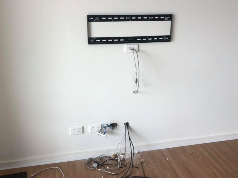 tv bracket attached to wall and showing cabling