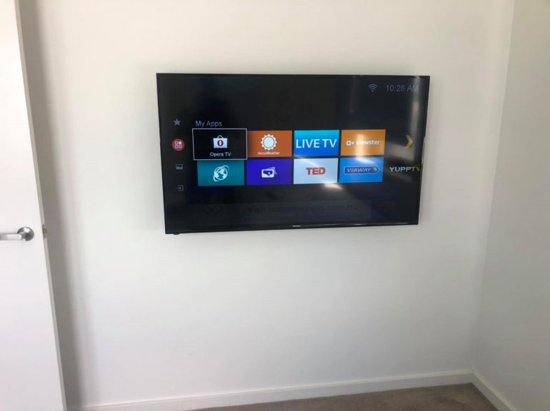 tv mounted in smaller room on opposite side of the wall