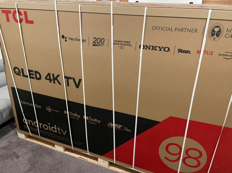 Box containing a TCL 98" QLED TV