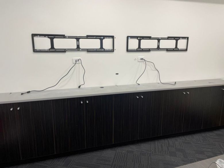 two sanus vxt7 brackets mounted on an office wall