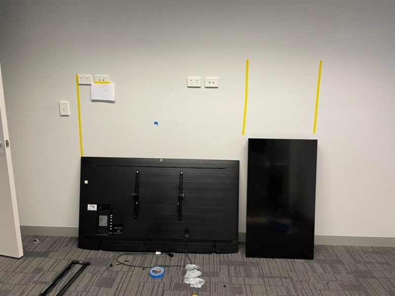 preparing to fit a tv and portrait monitor to the wall of an osborne park office