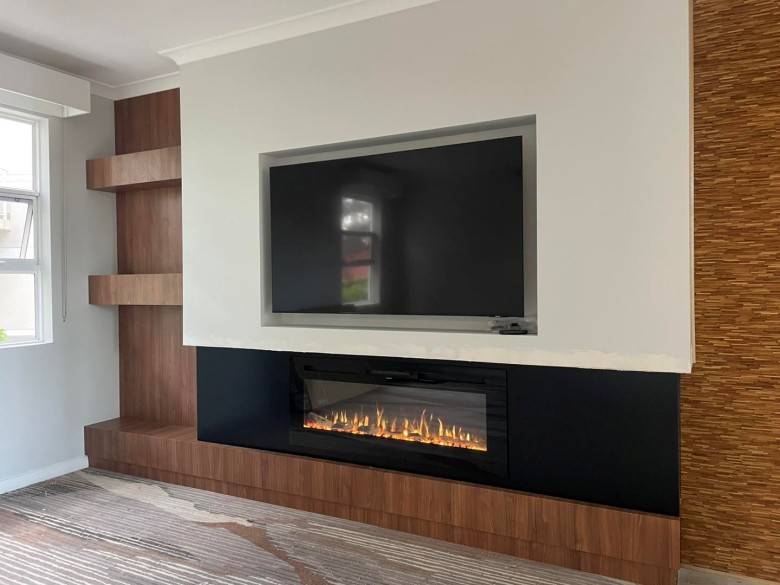 tv mounted in recess above fireplace