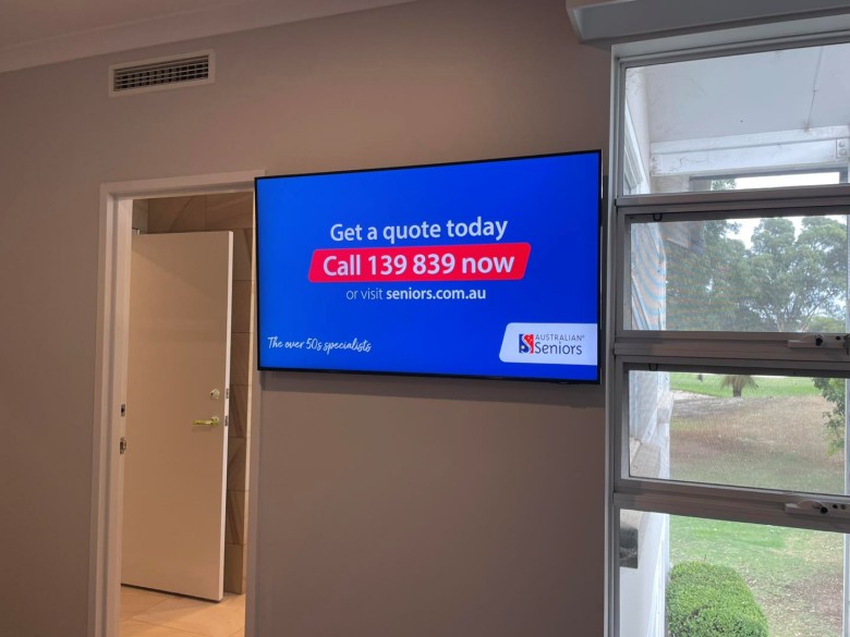 television mounted in tight space between door and window